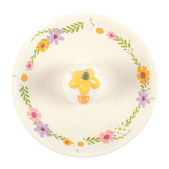 White trinket dish with floral detailing and a 3D duck in the centre. The duck is made more whimsical as it is wearing a yellow flower as a hat.