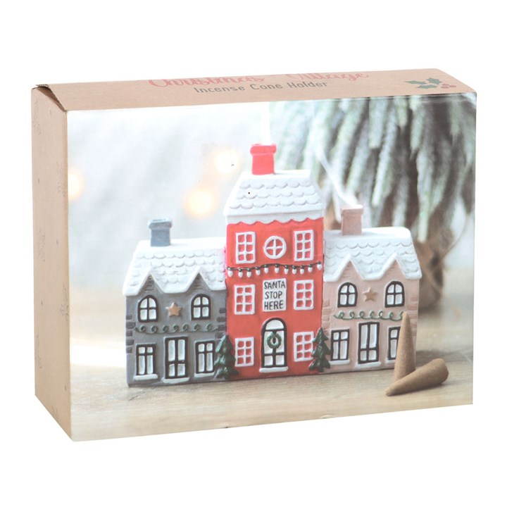 Ceramic incense cone burner shaped like a charming Christmas village with smoking chimney effect. Presented in a themed box.