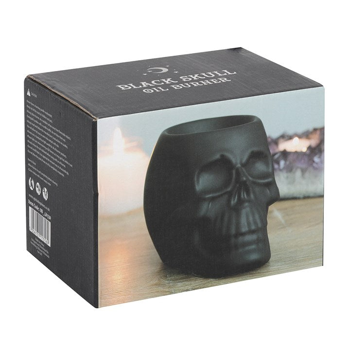 Black skull shaped wax melter and oil burner. Presented in a themed box.