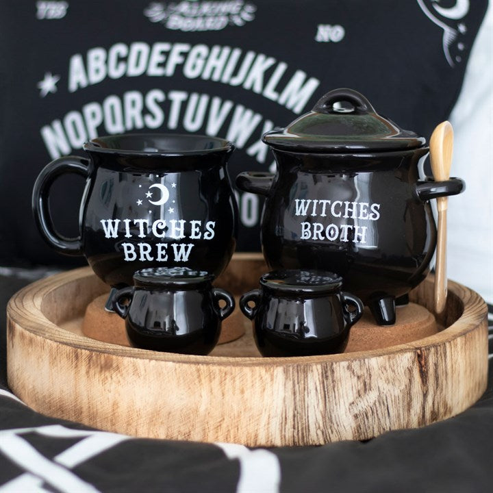 Two black cauldron-shaped salt and pepper shakers. Presented alongside other items from the same range.