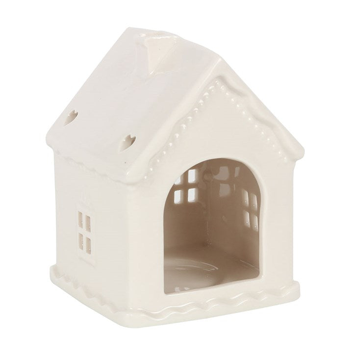 White ceramic tea light holder shaped like a traditional gingerbread house.