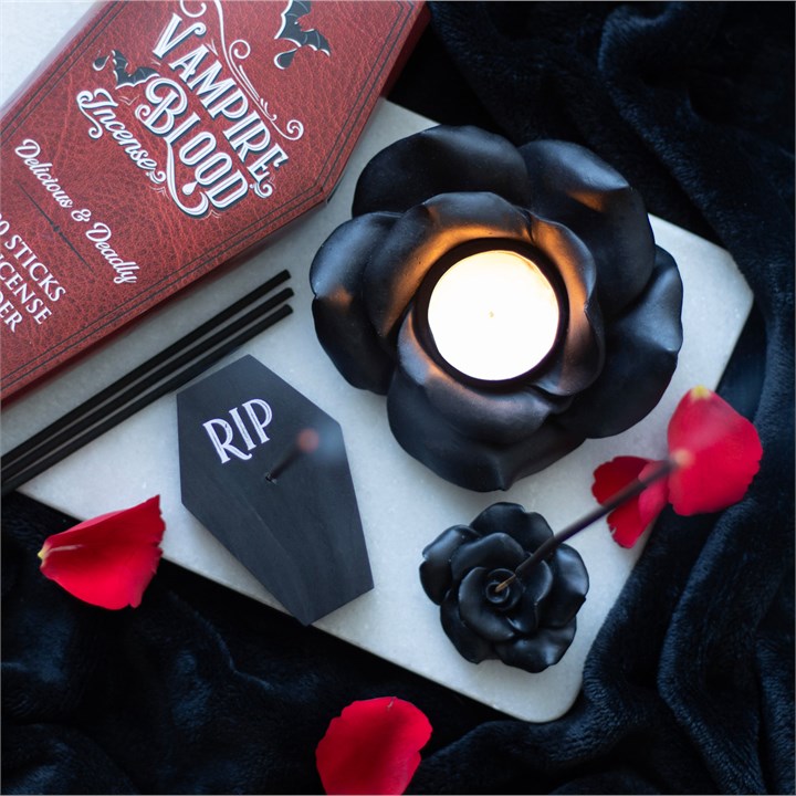 Resin tealight holder shaped like a dark rose in full bloom. Presented alongside other items from the same range.