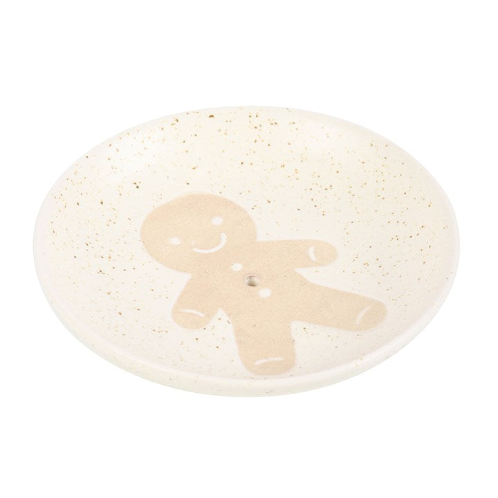 Ceramic incense dish featuring a smiling gingerbread man on a speckled, off white background.