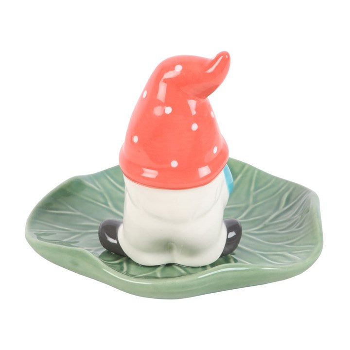 Gonk shaped incense stick holder, resting on a garden leaf.