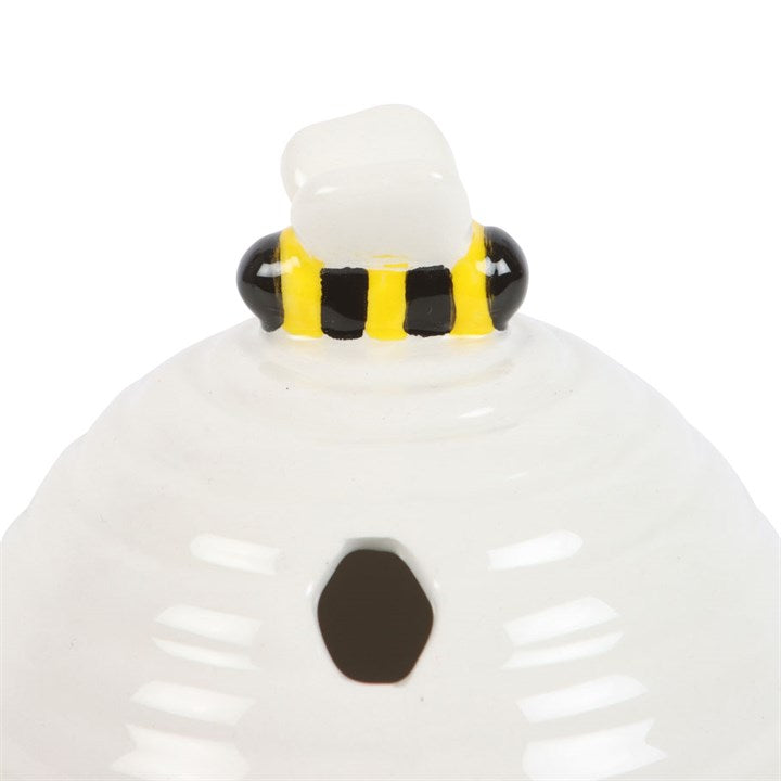 White beehive shaped ceramic incense cone burner. Close up of bee detailing.