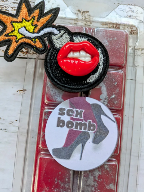 Sex Bomb coconut wax melt. Bright red snap bar with metallic grey shimmer accents.
