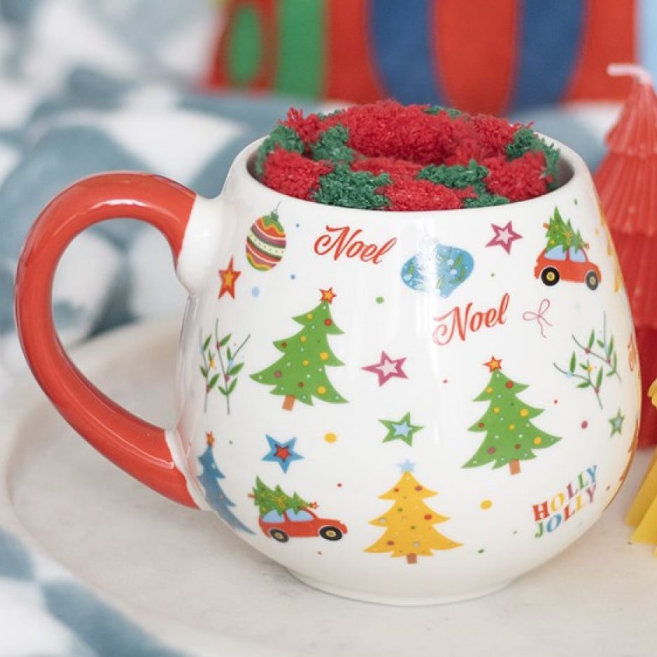 A rounded ceramic mug with traditional Christmas-icon motif, plus green and red striped fluffy socks.