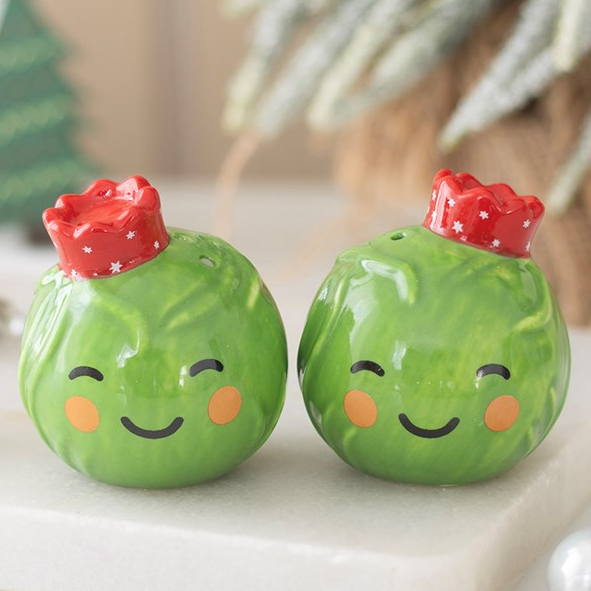 Adorable set of salt and pepper shakers, designed as two smiling Brussel sprouts topped with festive crowns.