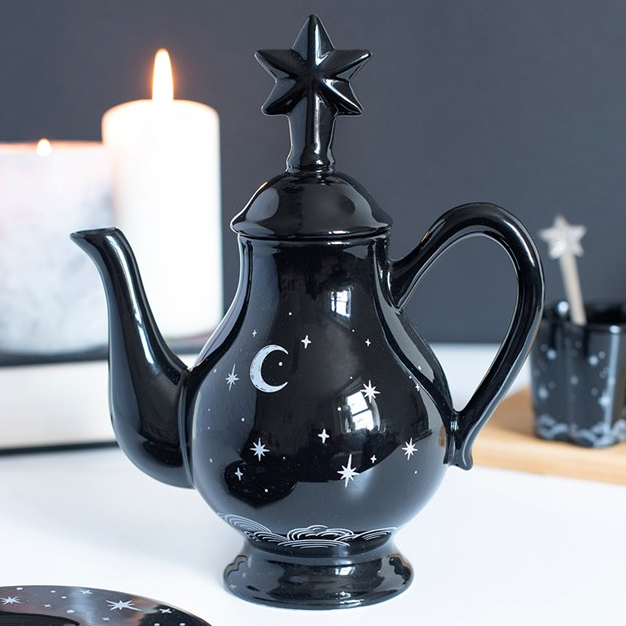 Striking tea pot with celestial design on a black background and a star-capped lid. 