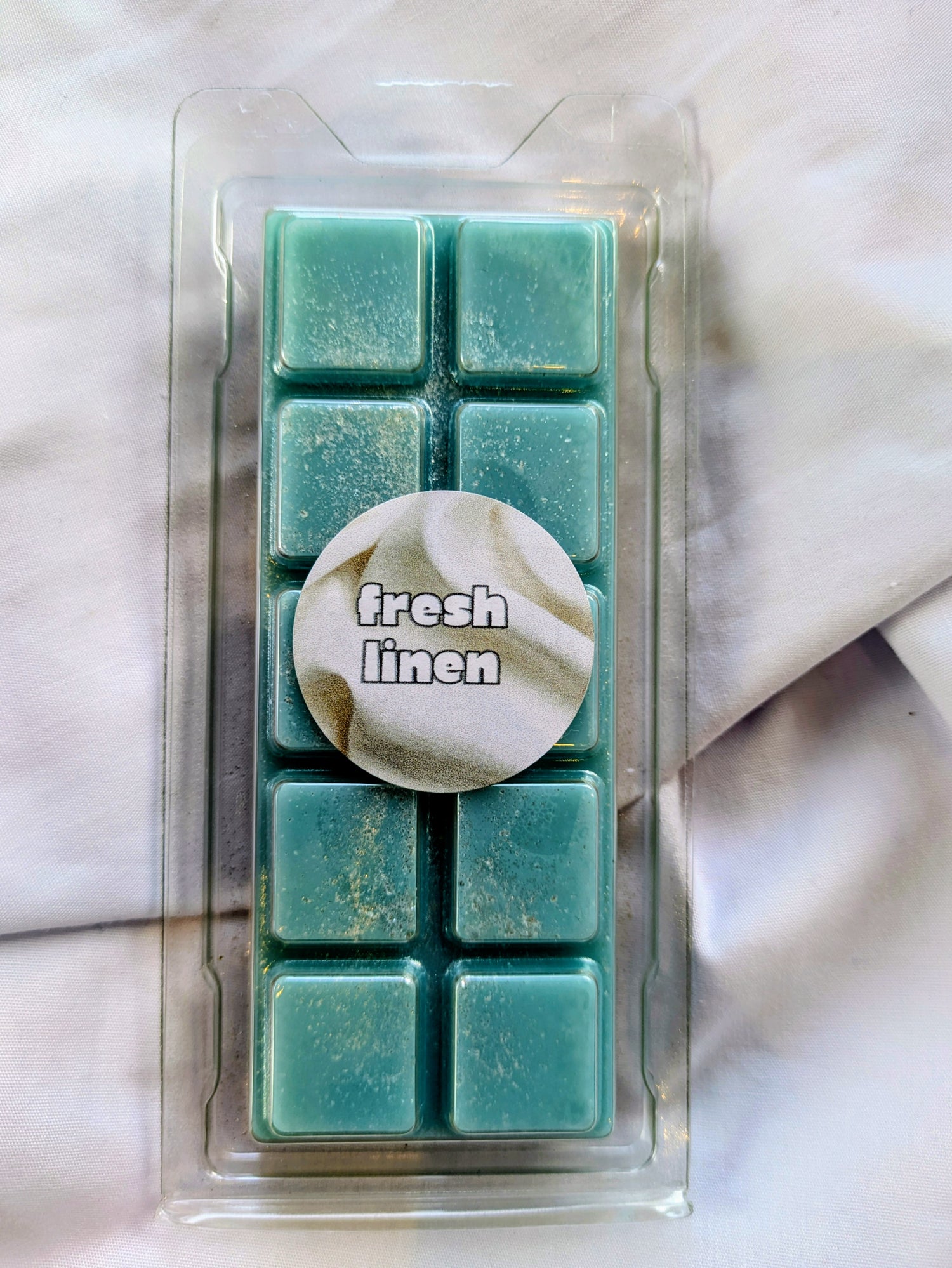 Fresh Linen coconut wax melt. Teal snap bar with silver and white shimmer accents.
