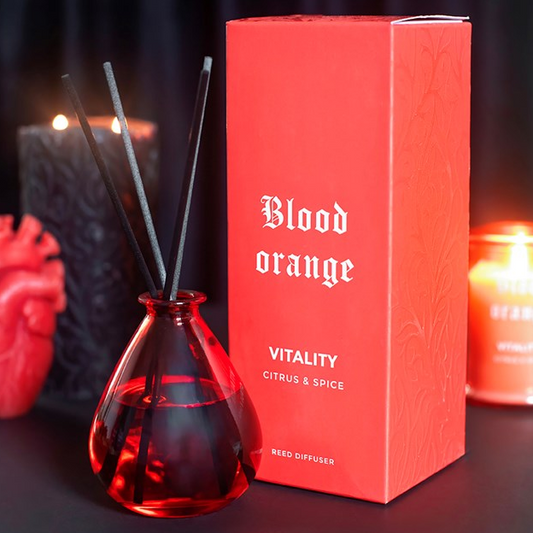 Blood Orange reed diffuser, presented in a deep orange teardrop bottle with black reeds. 