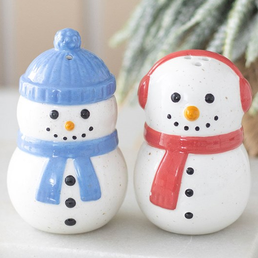Pair of ceramic snowman shaped salt and pepper shakers, finished with complementing red and blue accessories. 