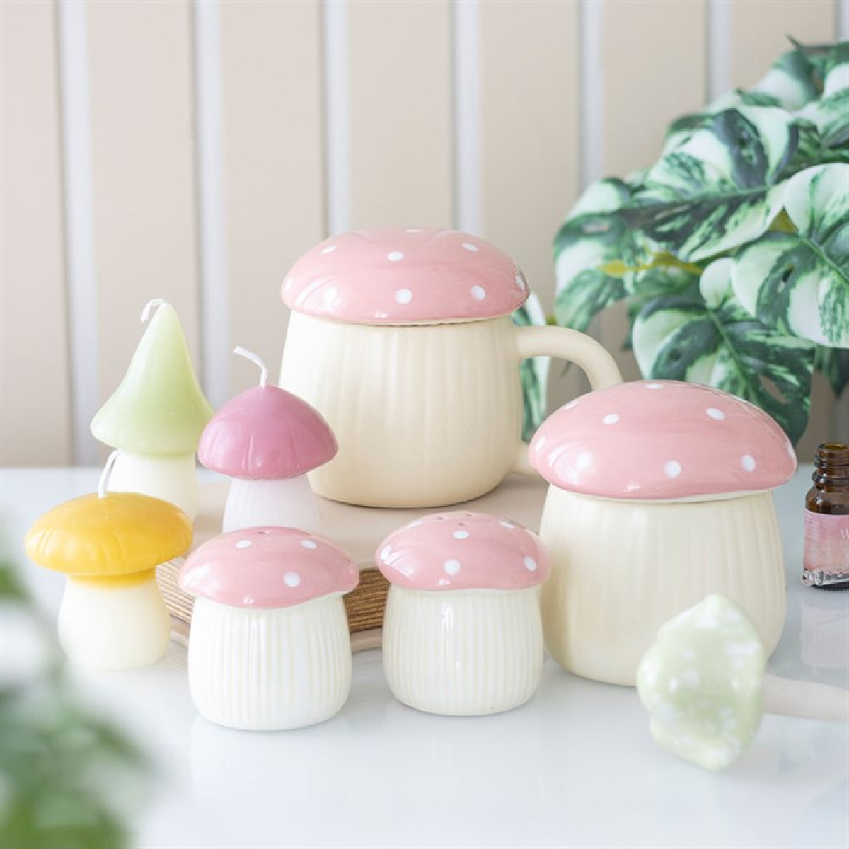 Pink ceramic mushroom shaped kitchenware including salt and pepper shakers, wax melter and lidded mug.