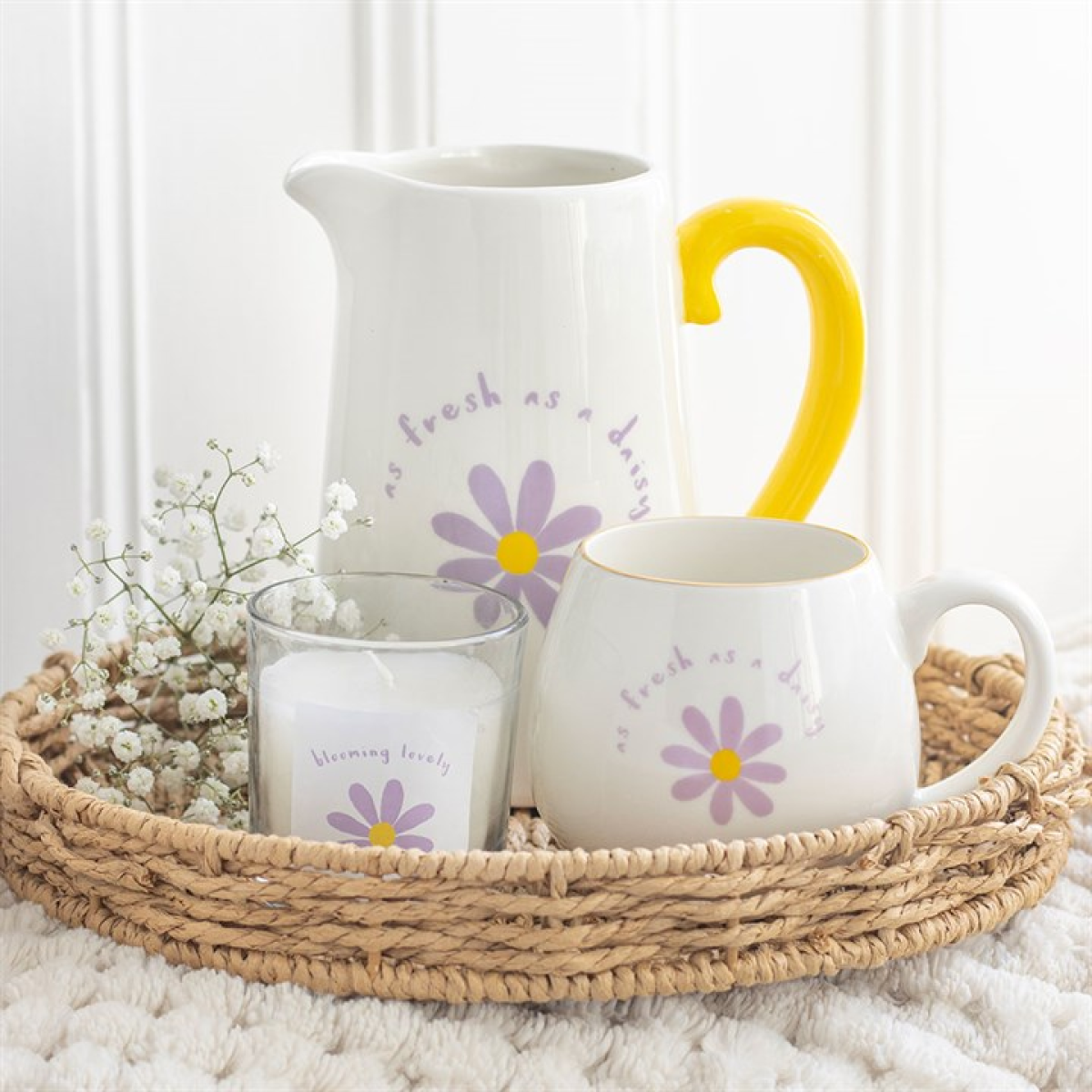 White ceramic flower jug with purple floral design, fresh as a daisy text and yellow handle. Presented alongside items from the same range.