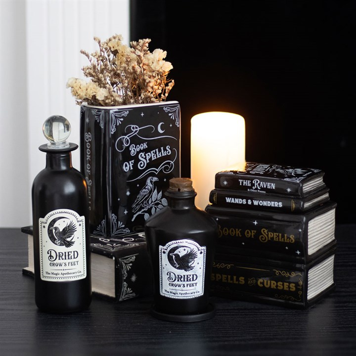 Book-shaped ceramic vase designed as an upright book of spells, complete with raven detailing. Presented alongside other items from the same range.