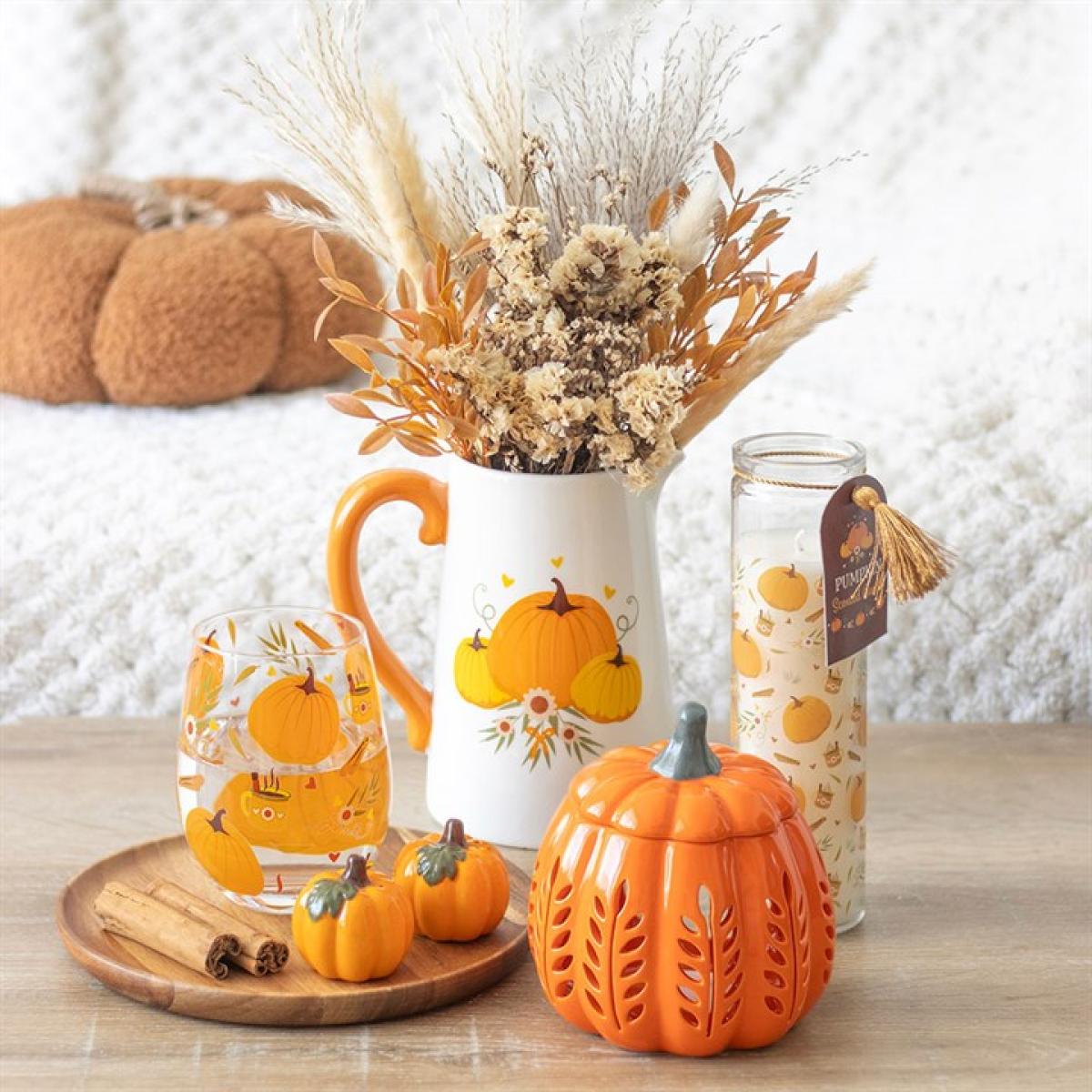 White pitcher flower jug with trio of pumpkin motif and orange handle. Presented next to other items from the same range.