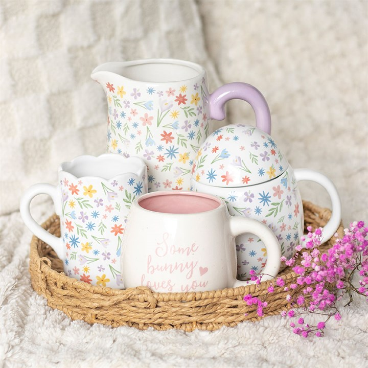 White ceramic flower jug with pastel floral motif. Presented alongside other items from the same range.