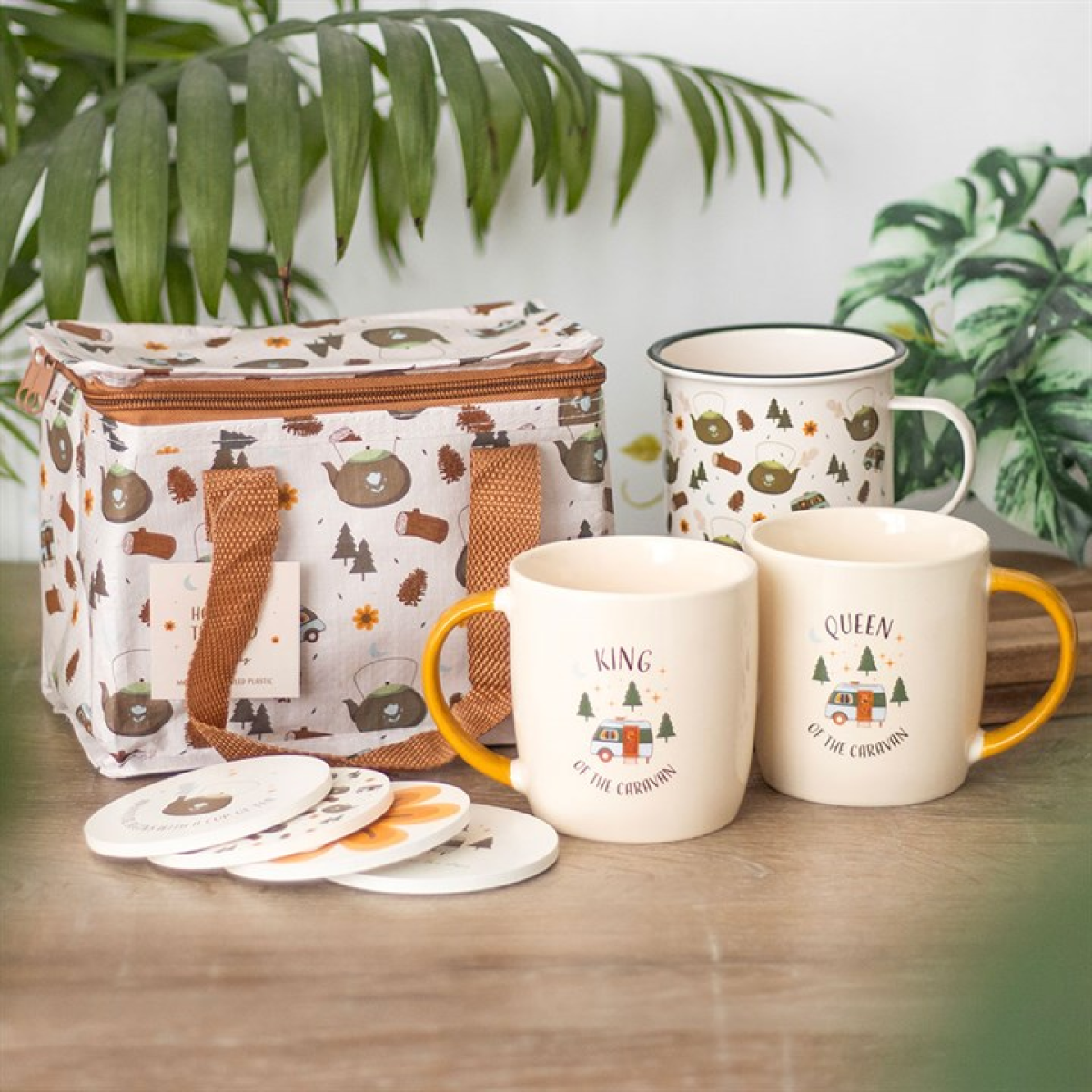 Enamel mug with camping-inspired pattern on a white background. Presented alongside other items from the same range.