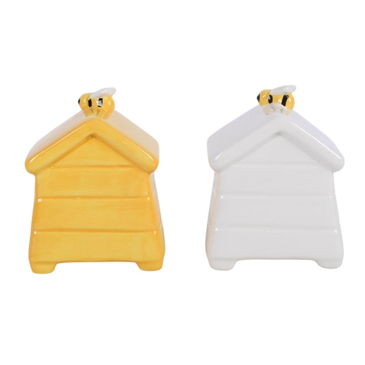 A set of white and yellow ceramic salt and pepper shakers, shaped like traditional beehives with a bee sitting on top. 