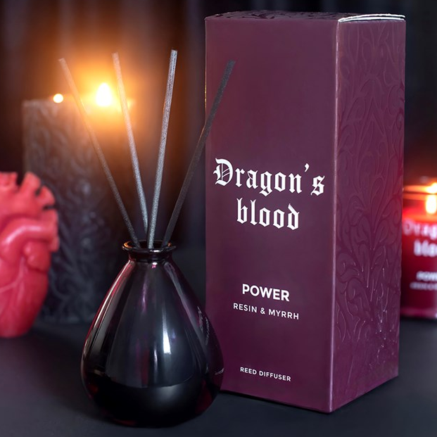 Dragon's Blood reed diffuser, presented in a deep purple teardrop glass bottle. 