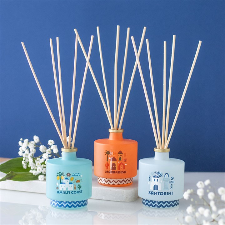 Marrakesh reed diffuser. Striking amber glass bottle with Moroccan architecture design. Presented alongside other items from the same range. 