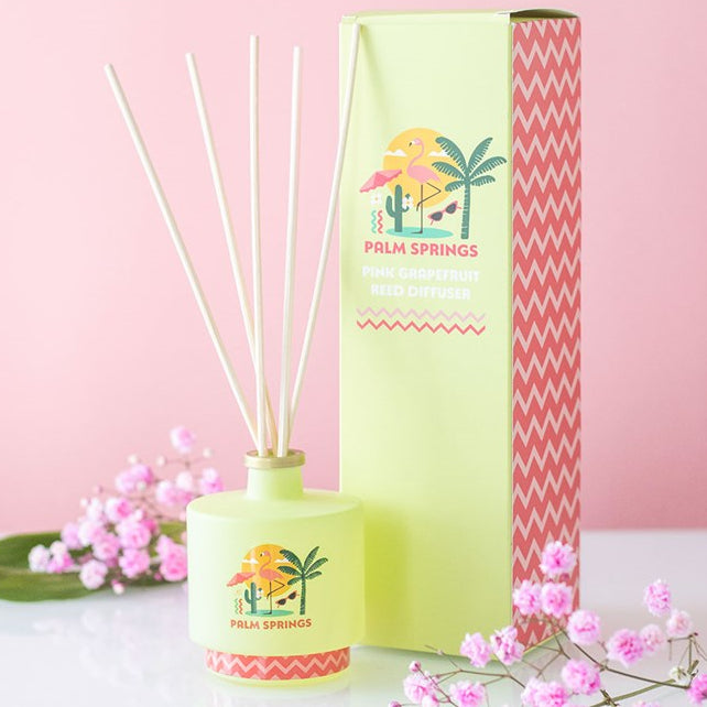 Palm Springs reed diffuser. Lime green bottle with palm tree and flamingo design. 