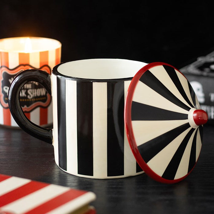 Monochrome striped circus tent-shaped ceramic mug with a pointed lid. 