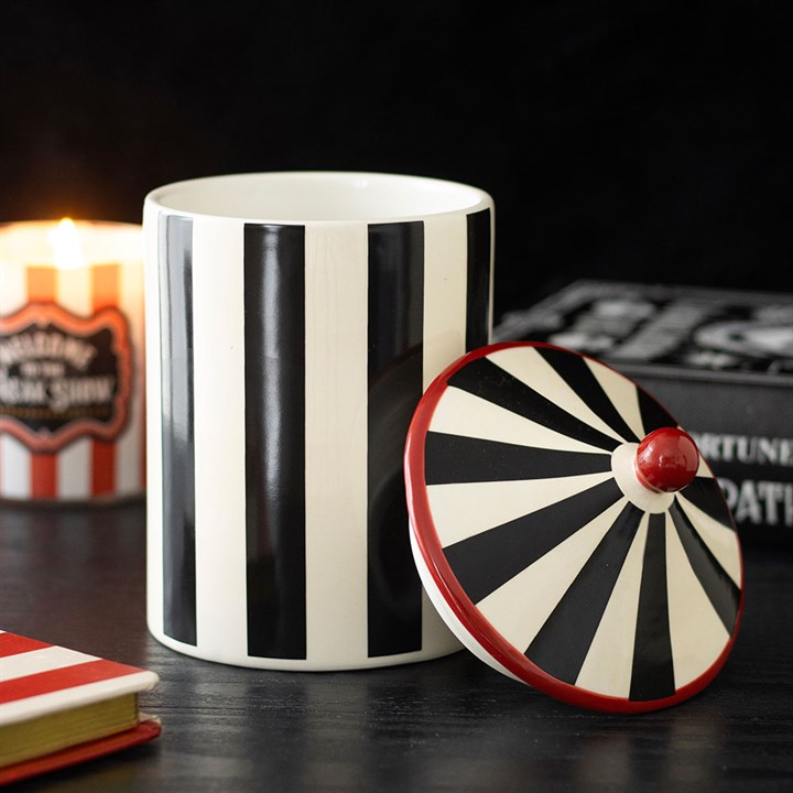 Black and white striped circus tent shaped storage jar.