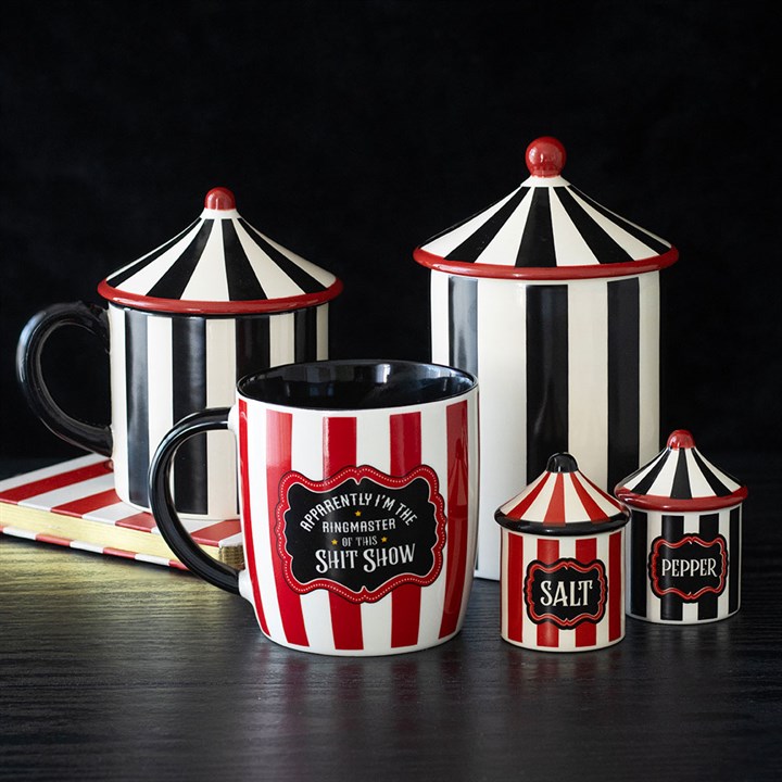 Black and white striped circus tent shaped storage jar. Presented alongside other items in the same range.