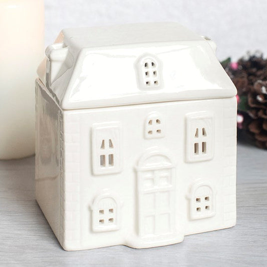White ceramic house-shaped wax melter and oil burner.