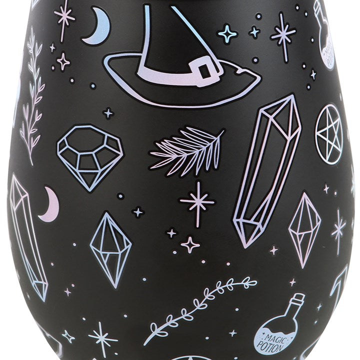 Close up of black stemless wine glass decorated with a crystal, potion, witches hat motif.
