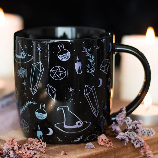 Black ceramic mug with white crystal witch style illustrations. 
