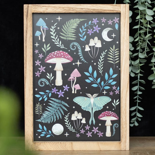 Framed wall art depicting a motif of dark forest items, magical mushrooms, luna moths, vintage fauna and celestial accents. 