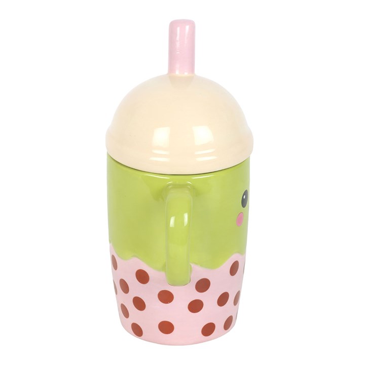 Ceramic mug shaped like an adorable Kawaii-inspired boba! Its domed pastel pink lid has a straw and the mug itself has a cute smiley face. Side view.