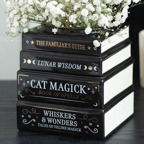 A black gothic themed flower vase, resembling a stack of spell and celestial books.