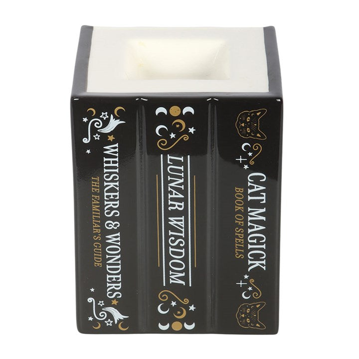 Ceramic wax melter and oil burner shaped like a trio of black cat-inspired spell books. 