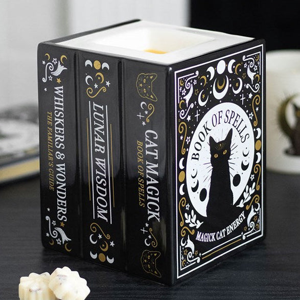 Ceramic wax melter and oil burner shaped like a trio of black cat-inspired spell books. 