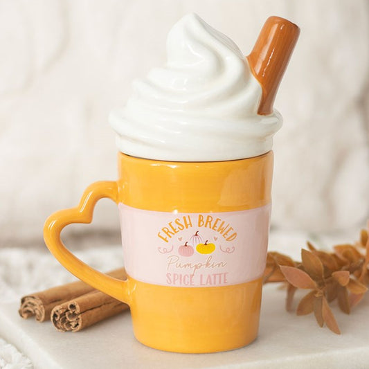 Fresh brewed pumpkin spiced latte mug with whipped cream shaped lid and cinnamon stick embellishment.