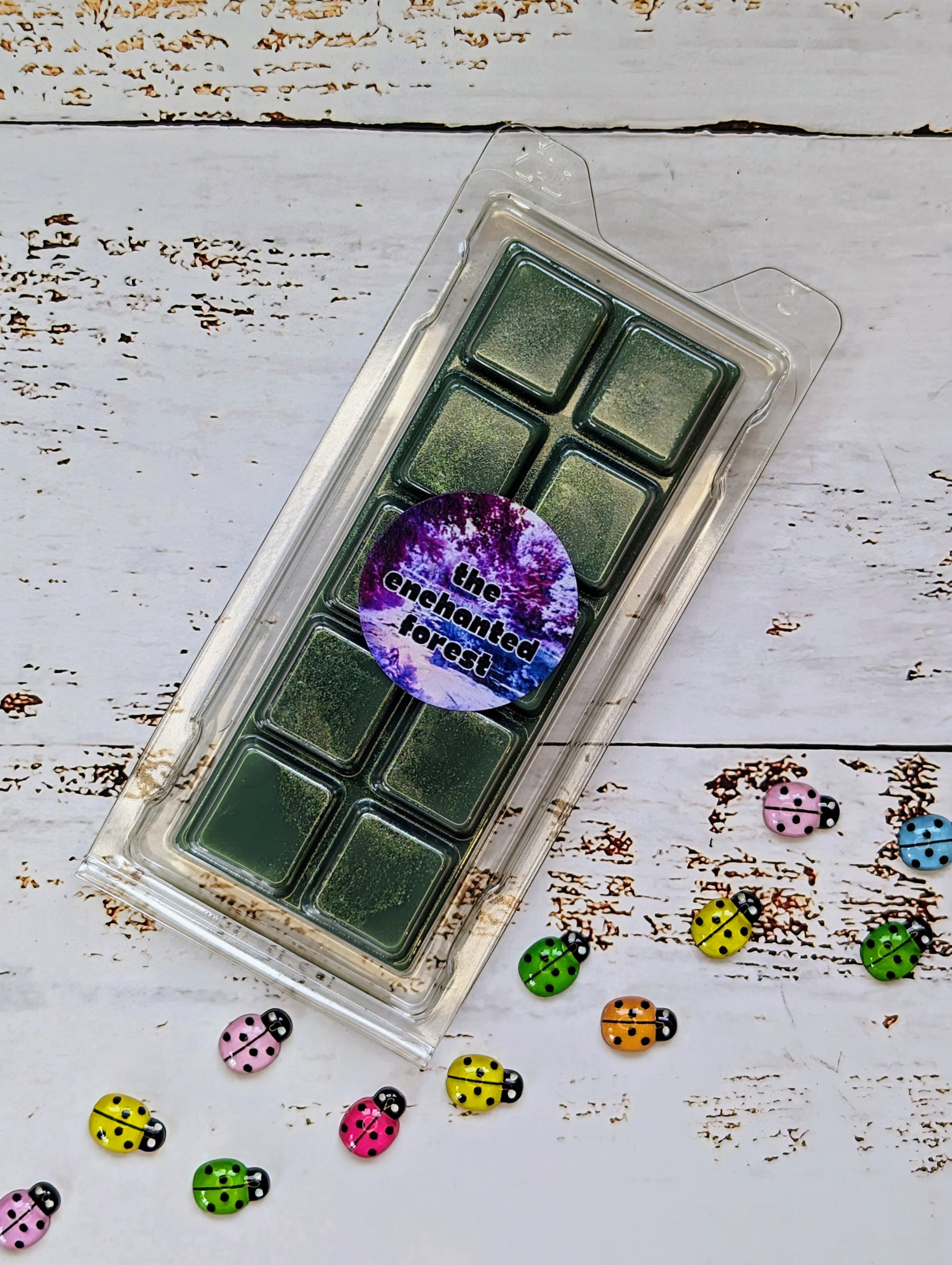 The Enchanted Forest coconut wax melt. Deep green snap bar with gold shimmer accent.