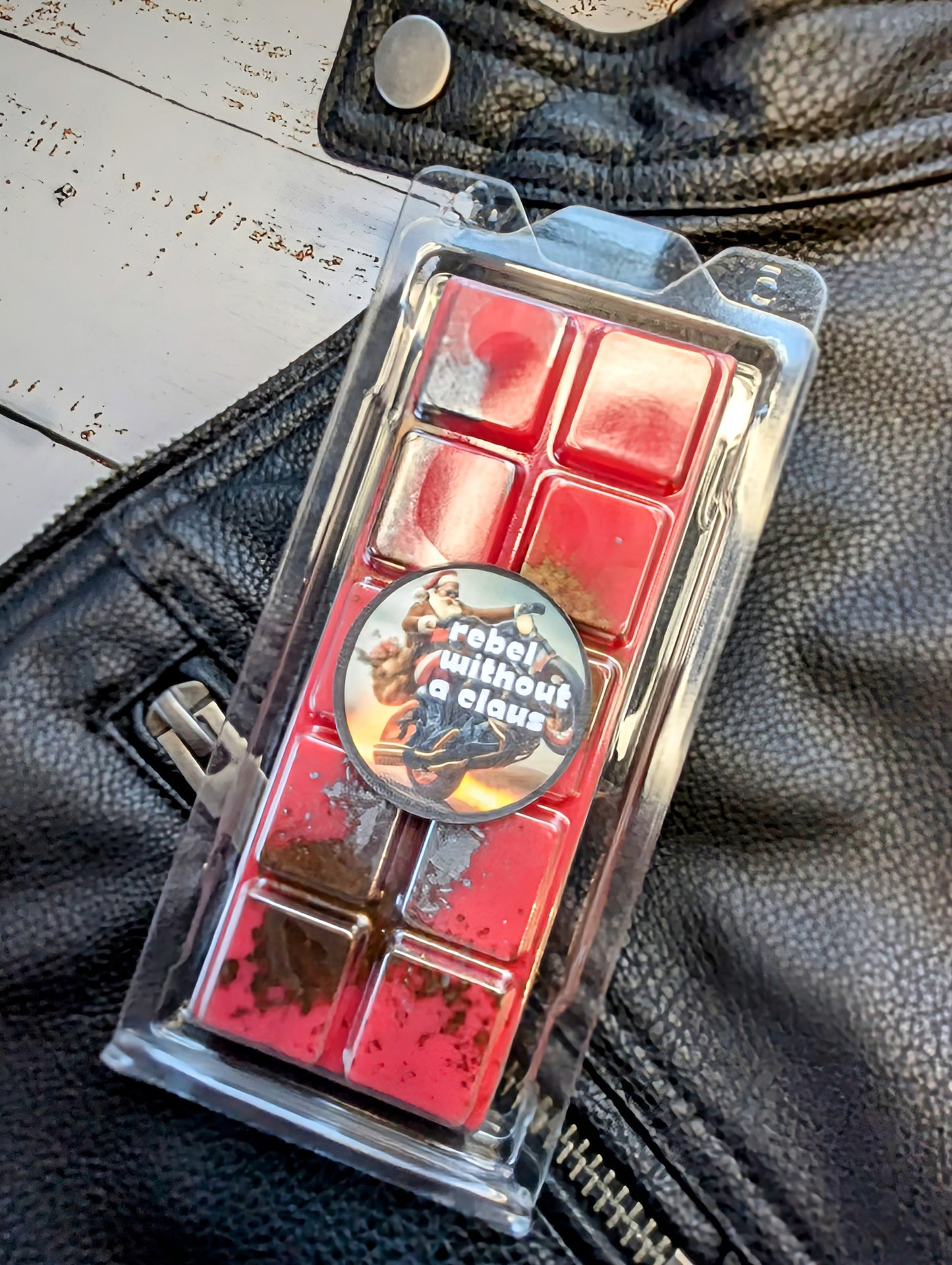 Rebel Without A Claus coconut wax melt. Bright red snap bar with bronze shimmer accents.