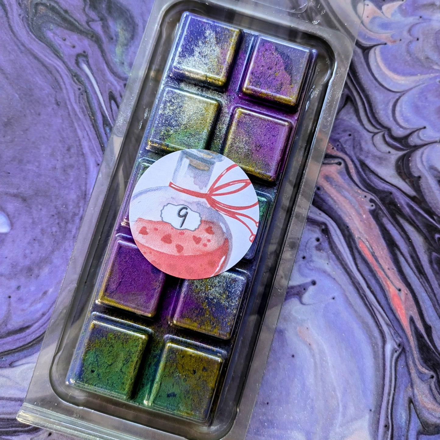 No. 9 coconut wax melt. Purple snap bar with green, gold and purple shimmer accents. 