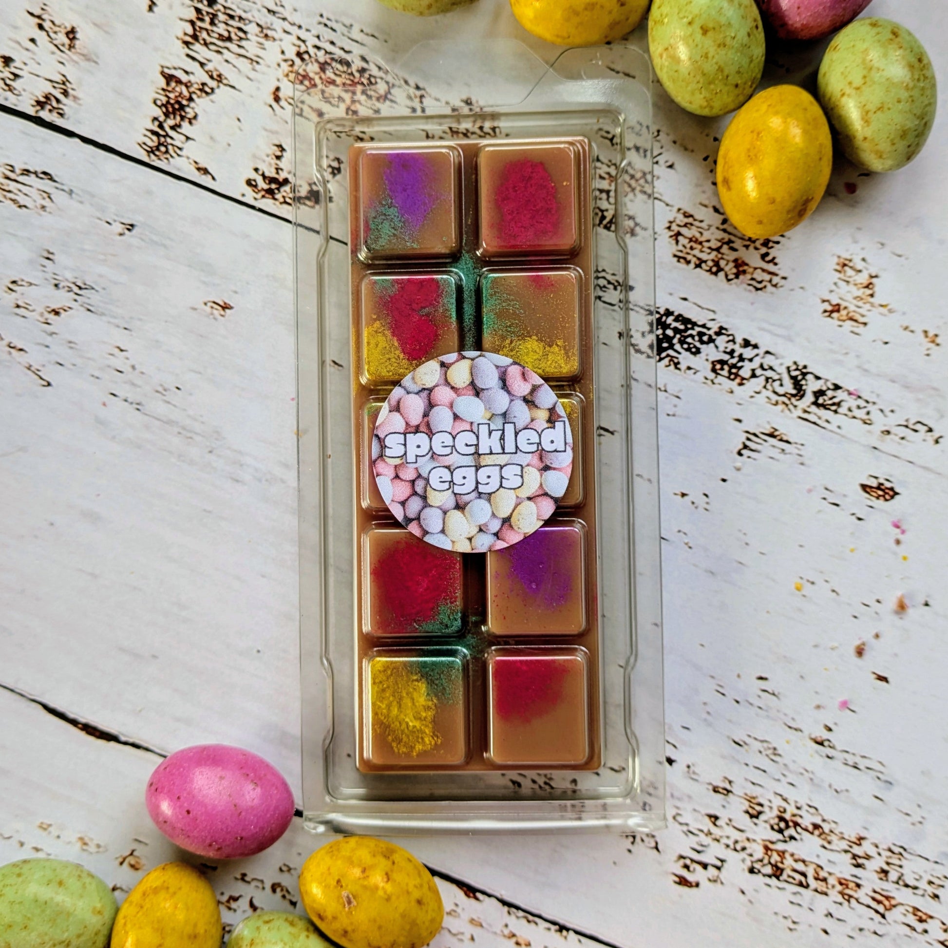 Speckled Eggs coconut wax melt. Dark brown snap bar with yellow, green, pink and purple shimmer accents.