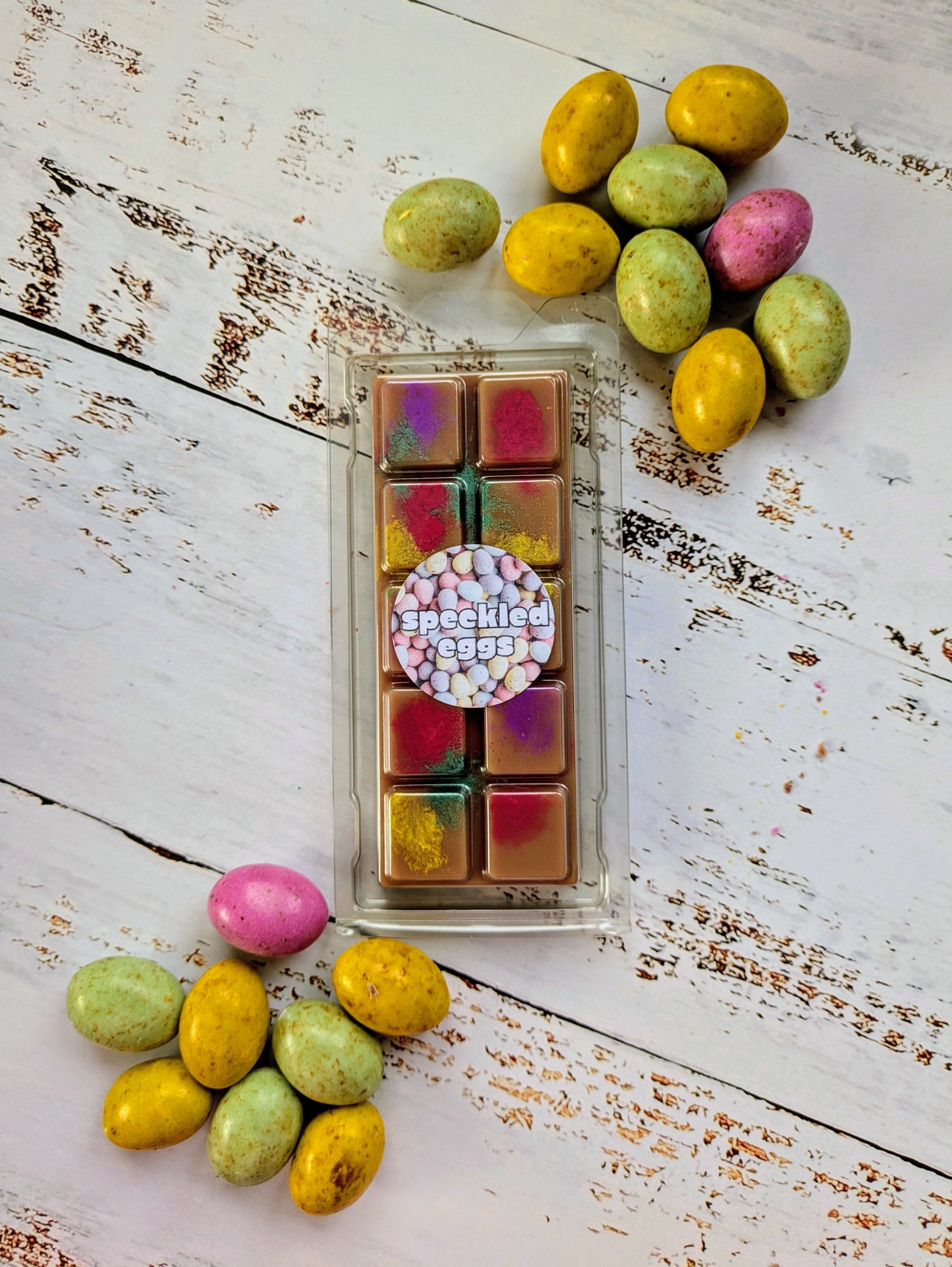Speckled Eggs coconut wax melt. Dark brown snap bar with yellow, green, pink and purple shimmer accents.