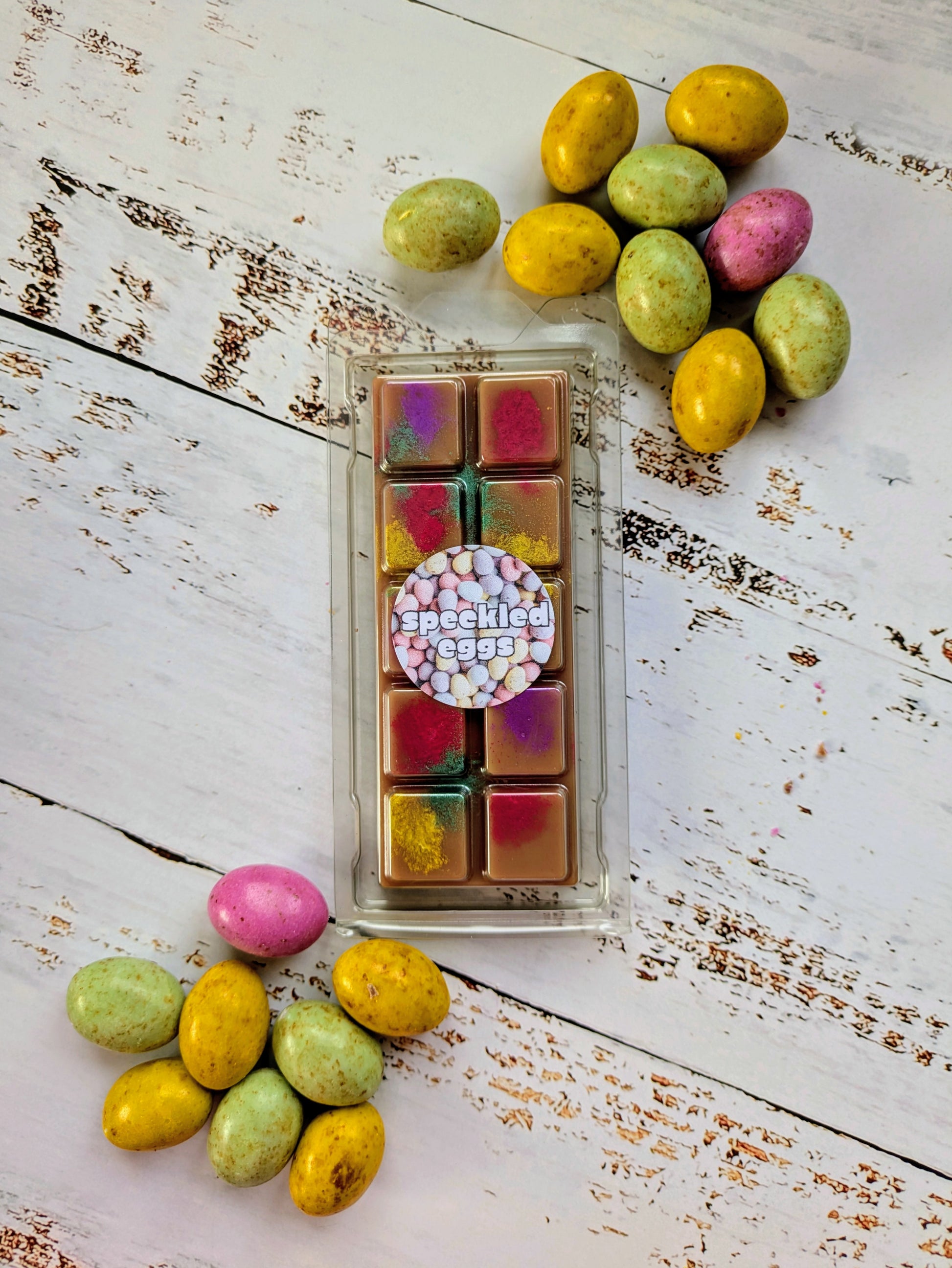 Speckled Eggs coconut wax melt. Dark brown snap bar with yellow, green, pink and purple shimmer accents.