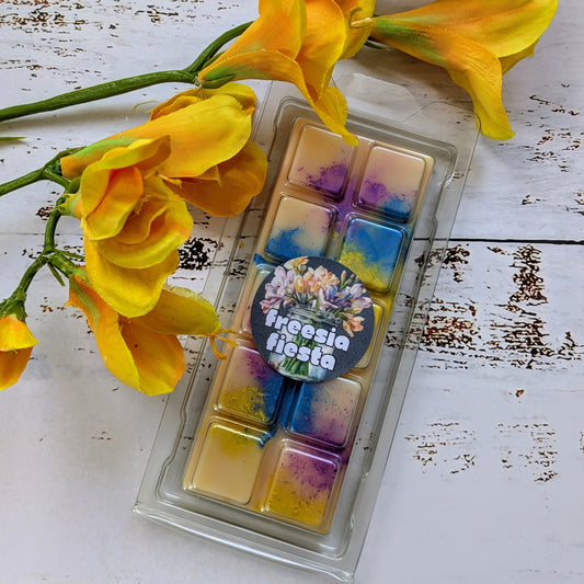 Freesia Fiesta coconut wax melt. Light yellow snap bar with purple, blue and yellow shimmer accents.