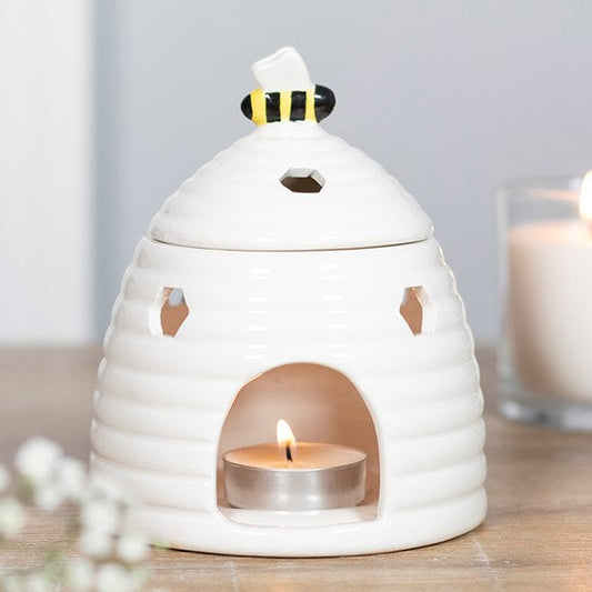White beehive shaped ceramic wax melter & oil burner. With honeycomb cut outs and a bee-topped lid.