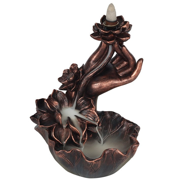 Intricate hand and flowers backflow incense burner in a dark copper effect finish.