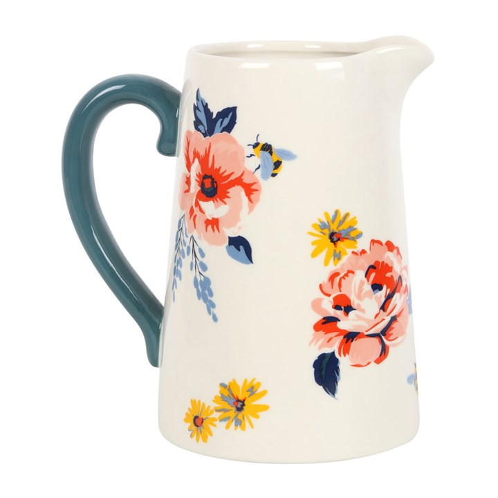 White pitcher with floral and bee illustrations and navy blue handle.
