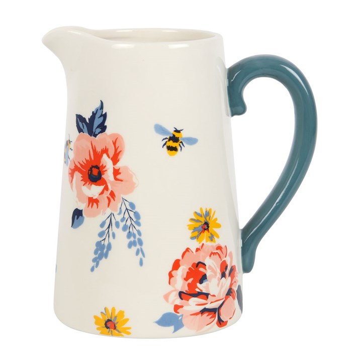 White pitcher with floral and bee illustrations and navy blue handle.