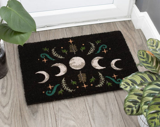 Decorative doormat with moon phases and vintage plants on a wooden floor.